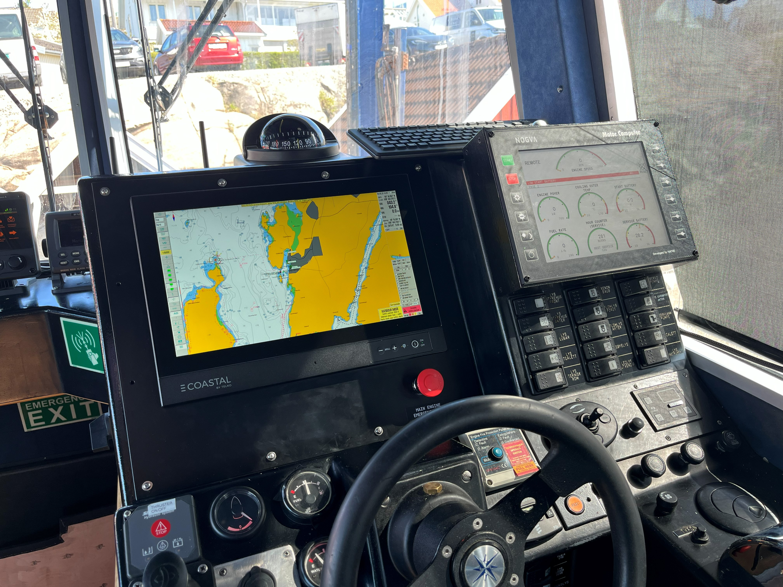 Interiør av en navigasjons- og overvåkingspanel i en yrkesbåt, med coastal e kartskjerm fra telko , instrumenter som måler motorens hastighet, kjølevannstemperatur, startbatteri og brenselforbruk.