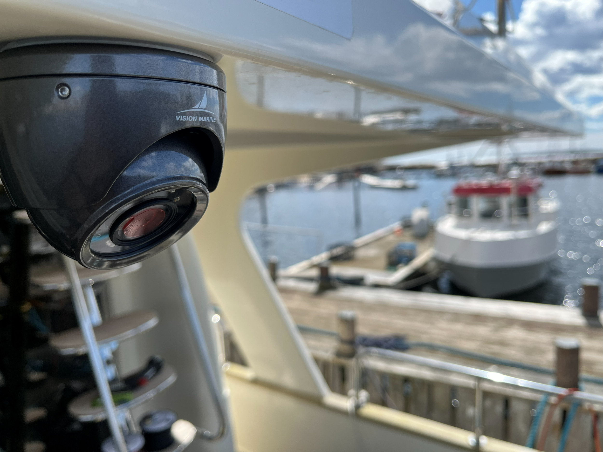 Nærbilde av en svart Vision Marine-båtmotor på en båt i en marina.