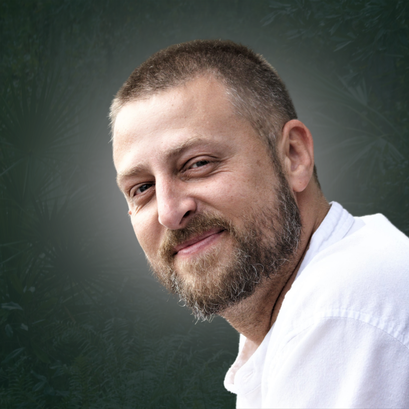 Andrew J. Assini spiritual guide smiling warmly in white shirt outdoors