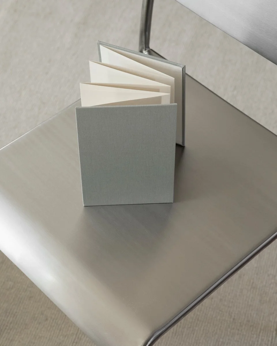 A small, gray organizer with calendar pages on a metal surface.