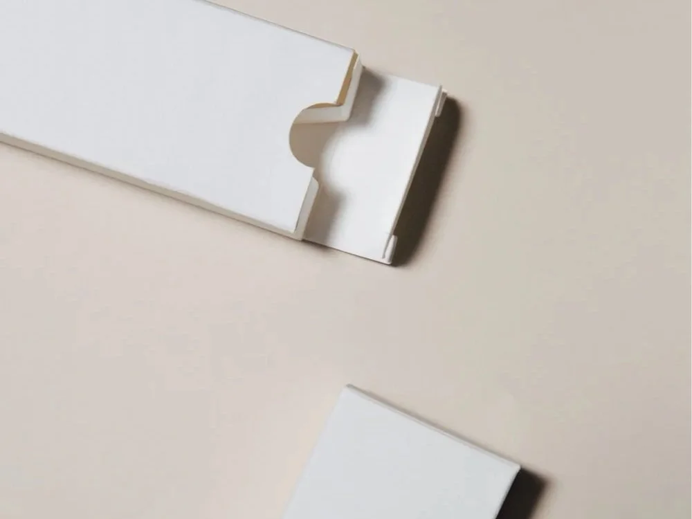 White product packaging against a beige background.