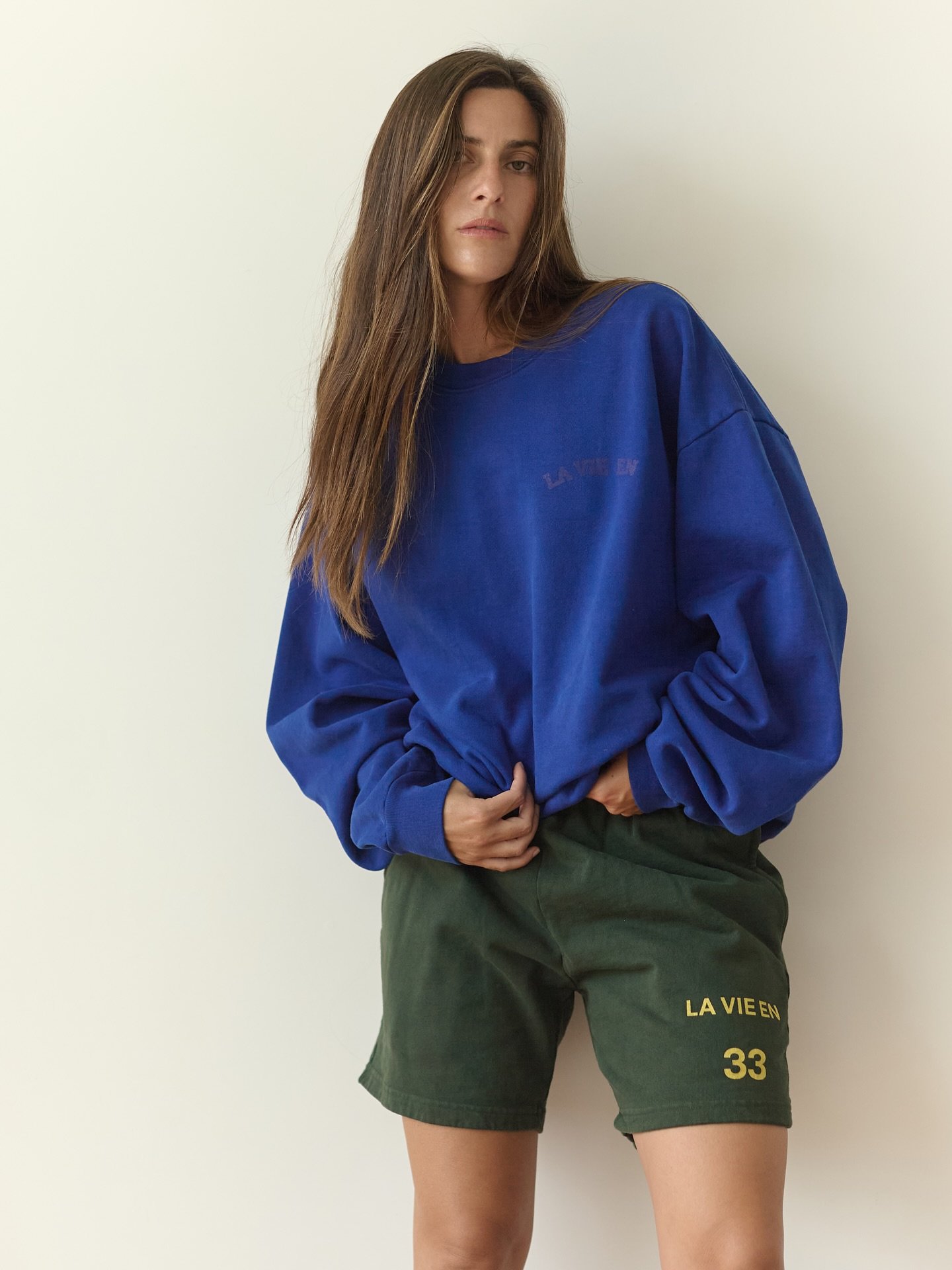 la vie en Sport Shorts. In 14oz heavyweight cotton fleece. Low rise or mid, with an adjustable drawstring. Vanessa wears a size small in Ivy.