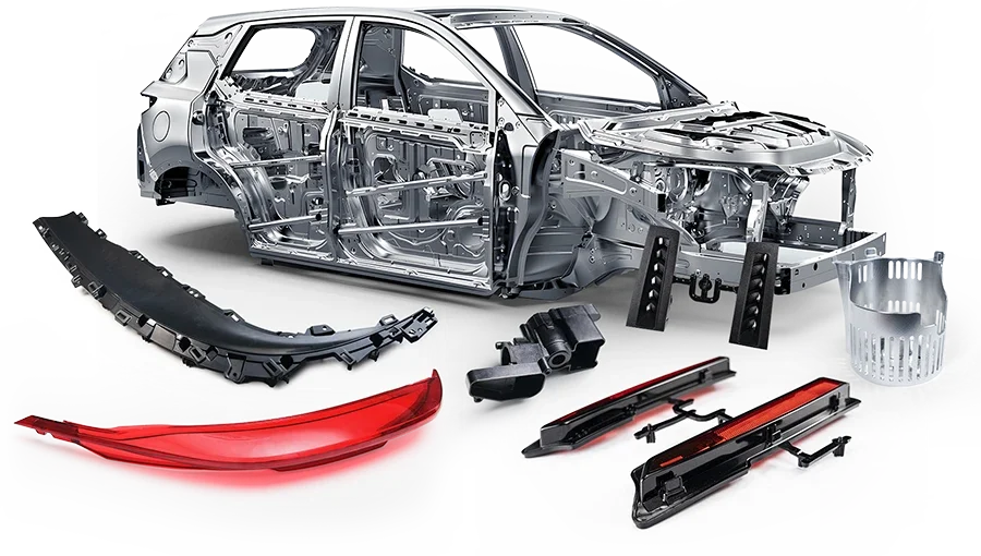 Disassembled car frame and parts laid out on a plain background, including a partially assembled car body, a red tail light, black bumper pieces, and other smaller mechanical parts.