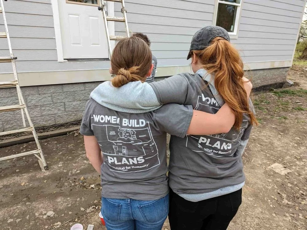 Partners on a build site hugging