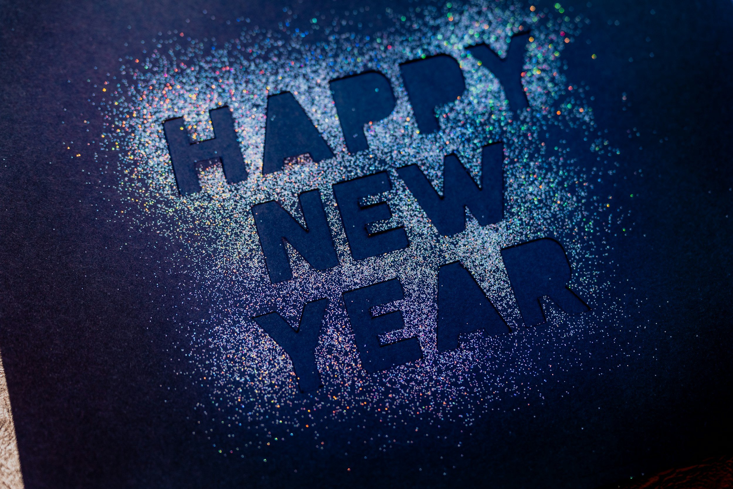 Happy New Year sparkling with glitter, symbolizing new beginnings and joyful reflection with TheraSistersSTL.