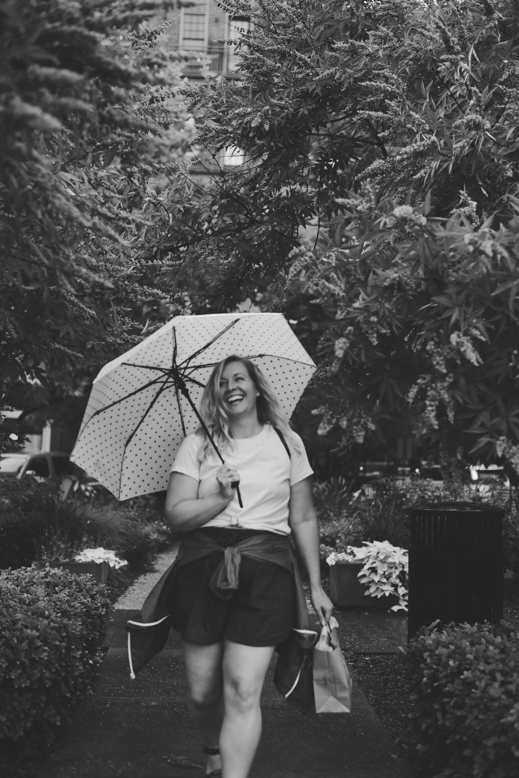 Black and white photo of a woman finding happiness despite the rain, reflecting TheraSistersSTL's guide to letting loose.