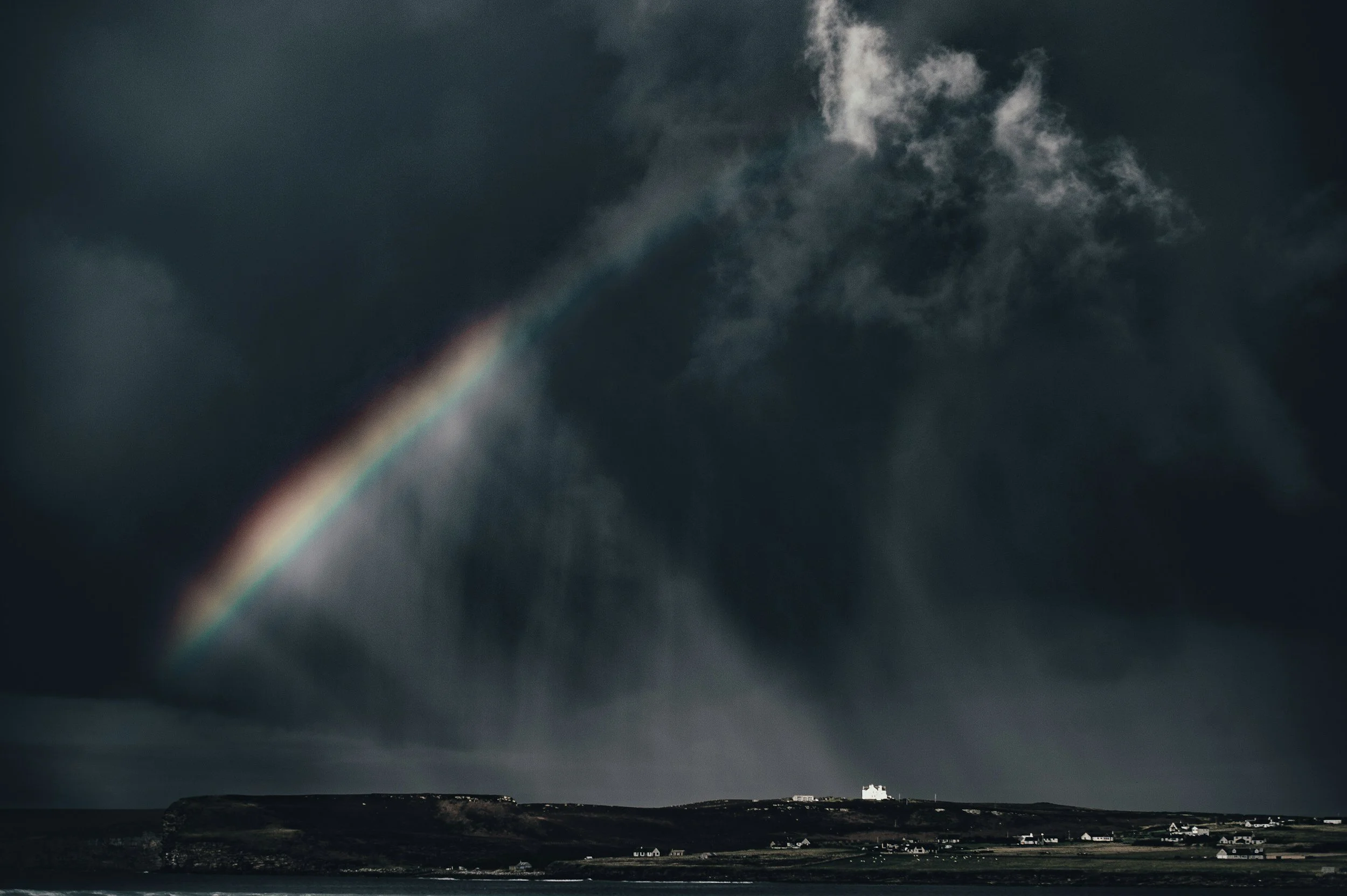 A vibrant rainbow against a dark sky, symbolizing hope and finding 'glimmers' after challenges, as inspired by TheraSistersSTL