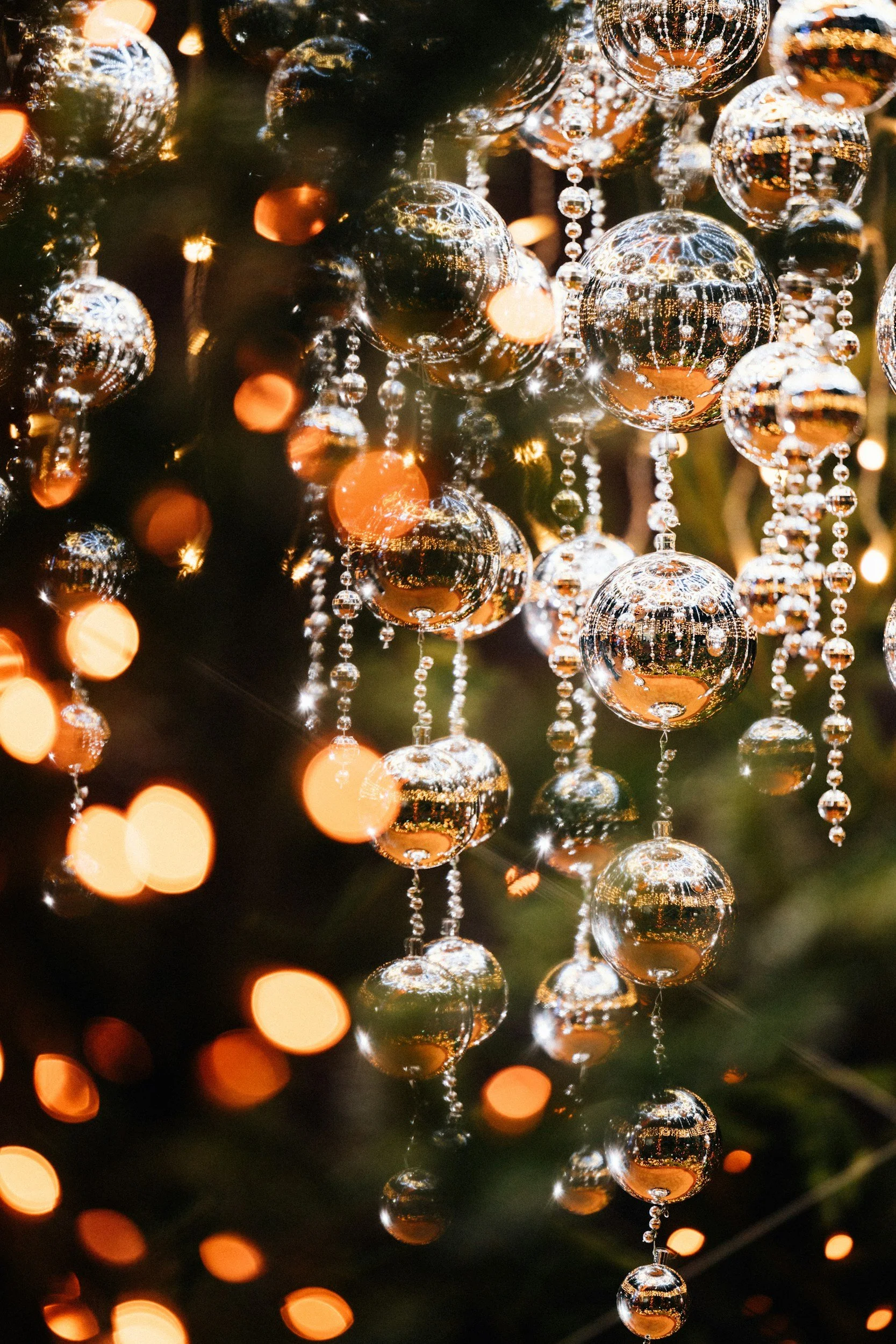 a close up of clear sparkly ornaments dangling from a tree