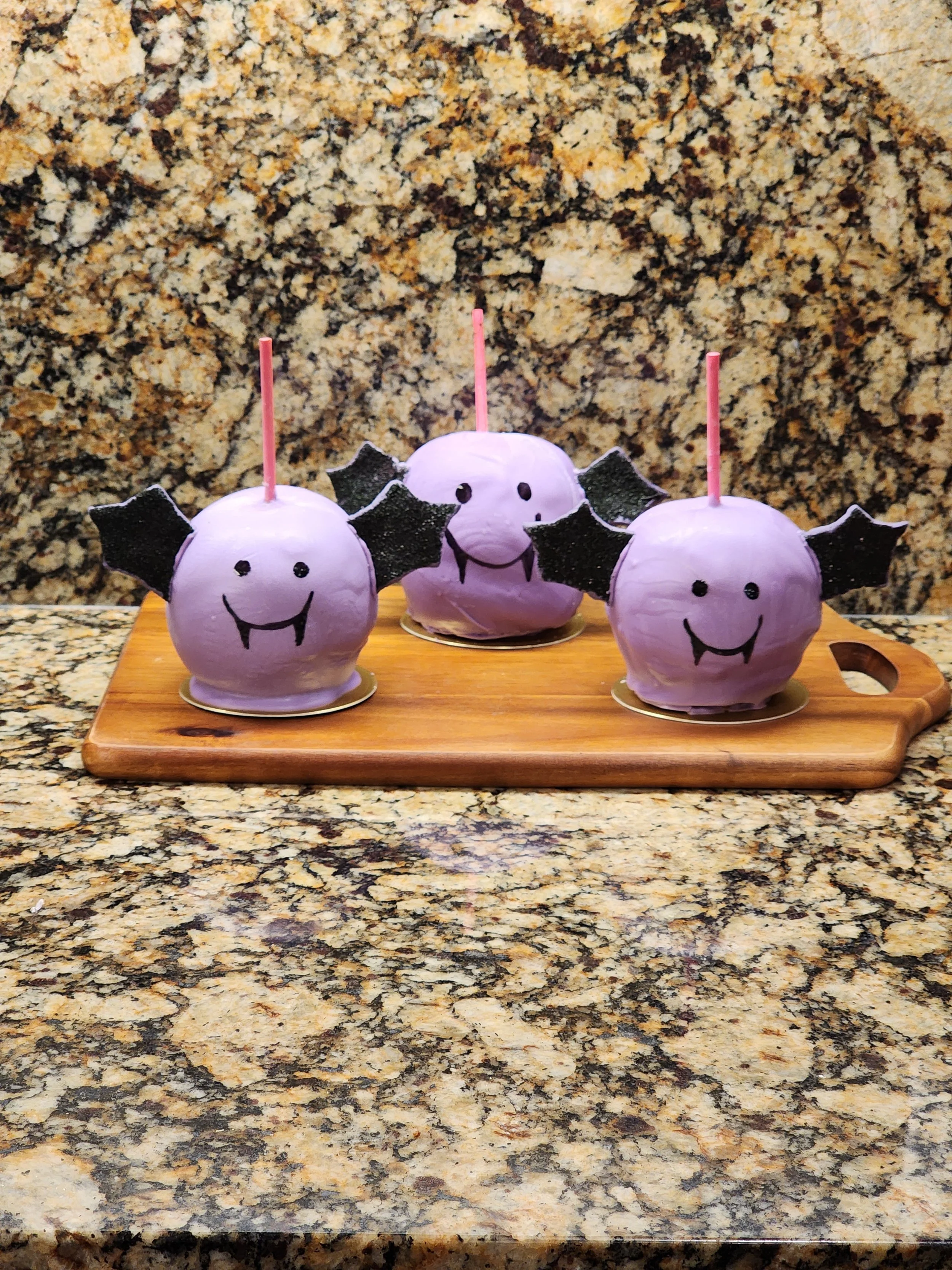 Lavender chocolate happy bat-shaped caramel apples with sparkly back wing