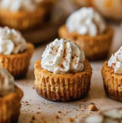 Mini pumpkin cheesecake bites topped with whipped cream and a dusting of cinnamon, part of the Spiced Chai dessert lineup.
