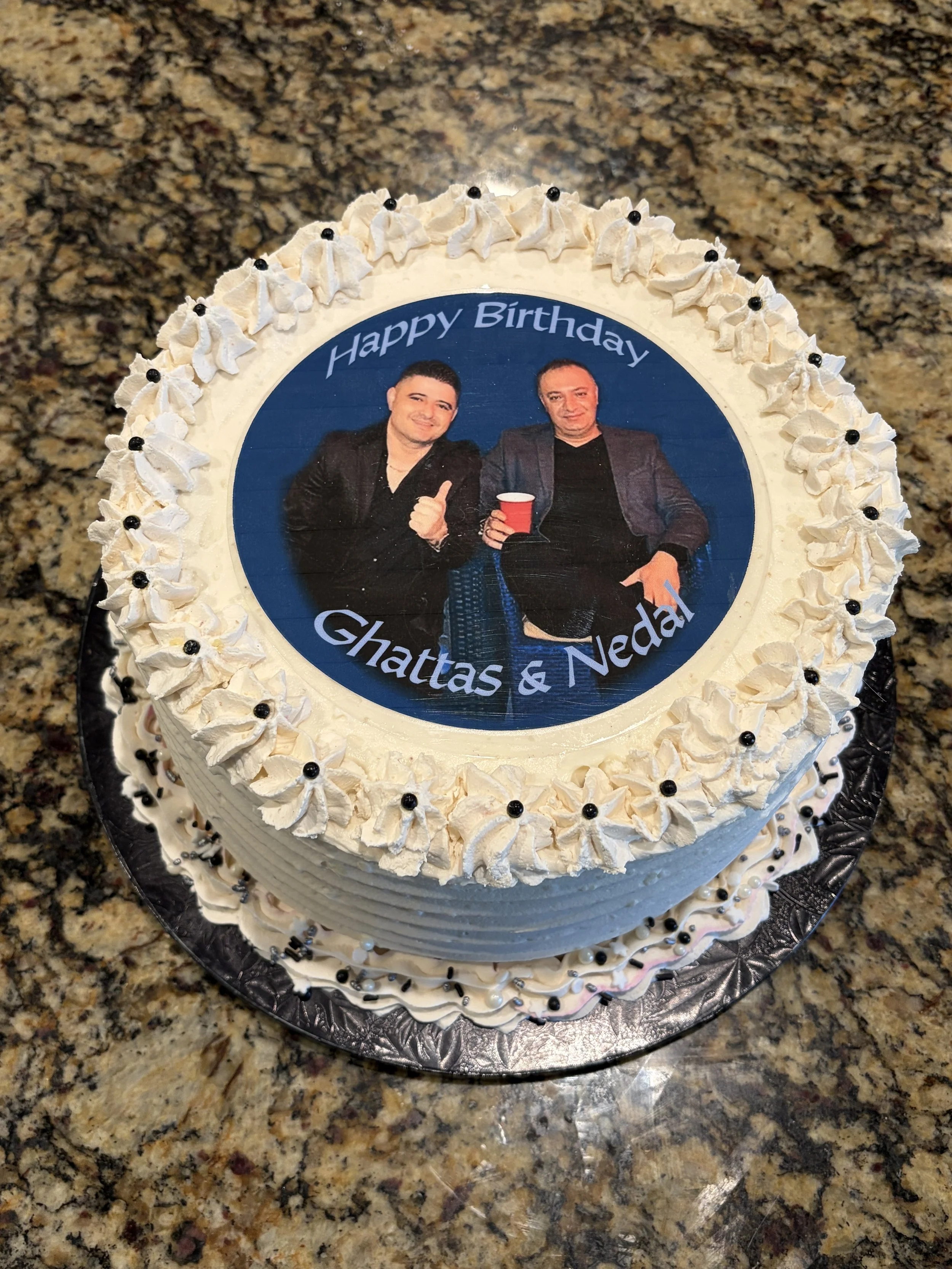 A round cake with a personal photo print and "Happy Birthday" lettering.