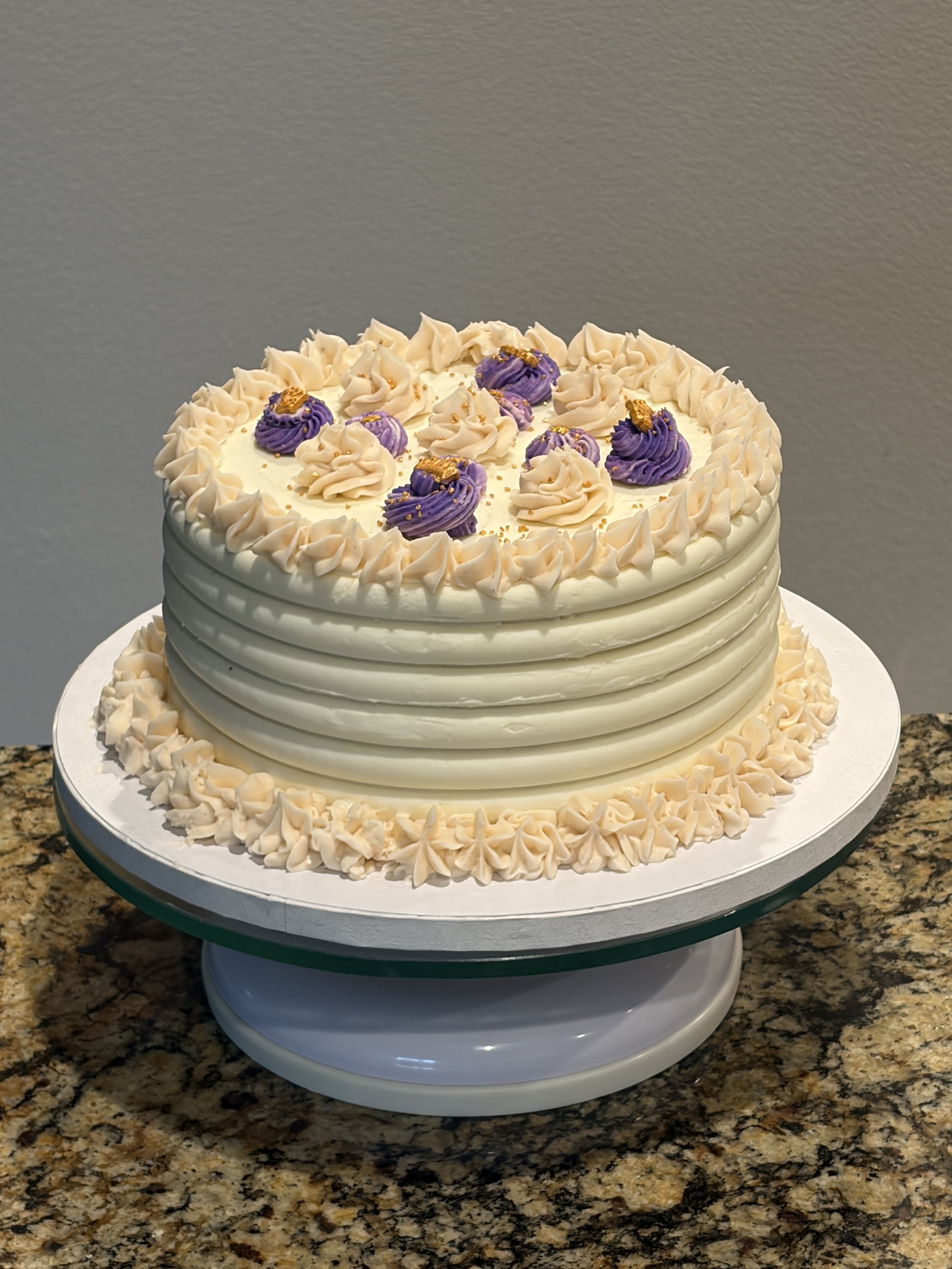 A white ridged cake with small purple flower accents on top.