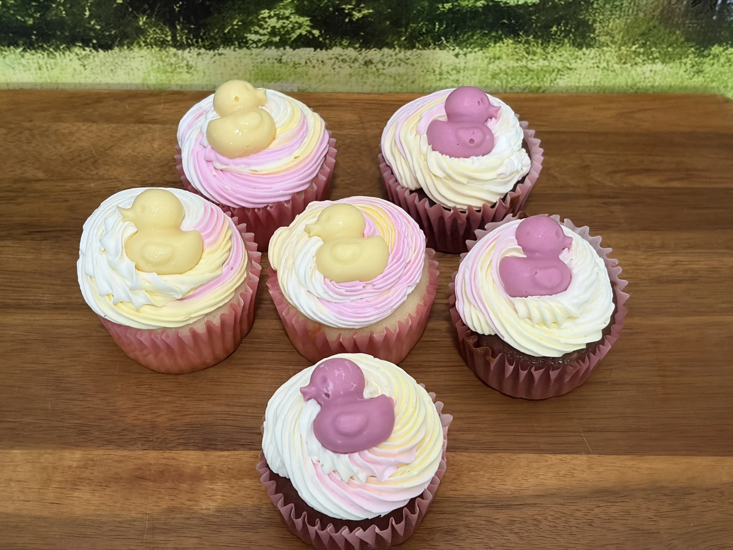 Pink and white cupcakes topped with pastel fondant duck decorations