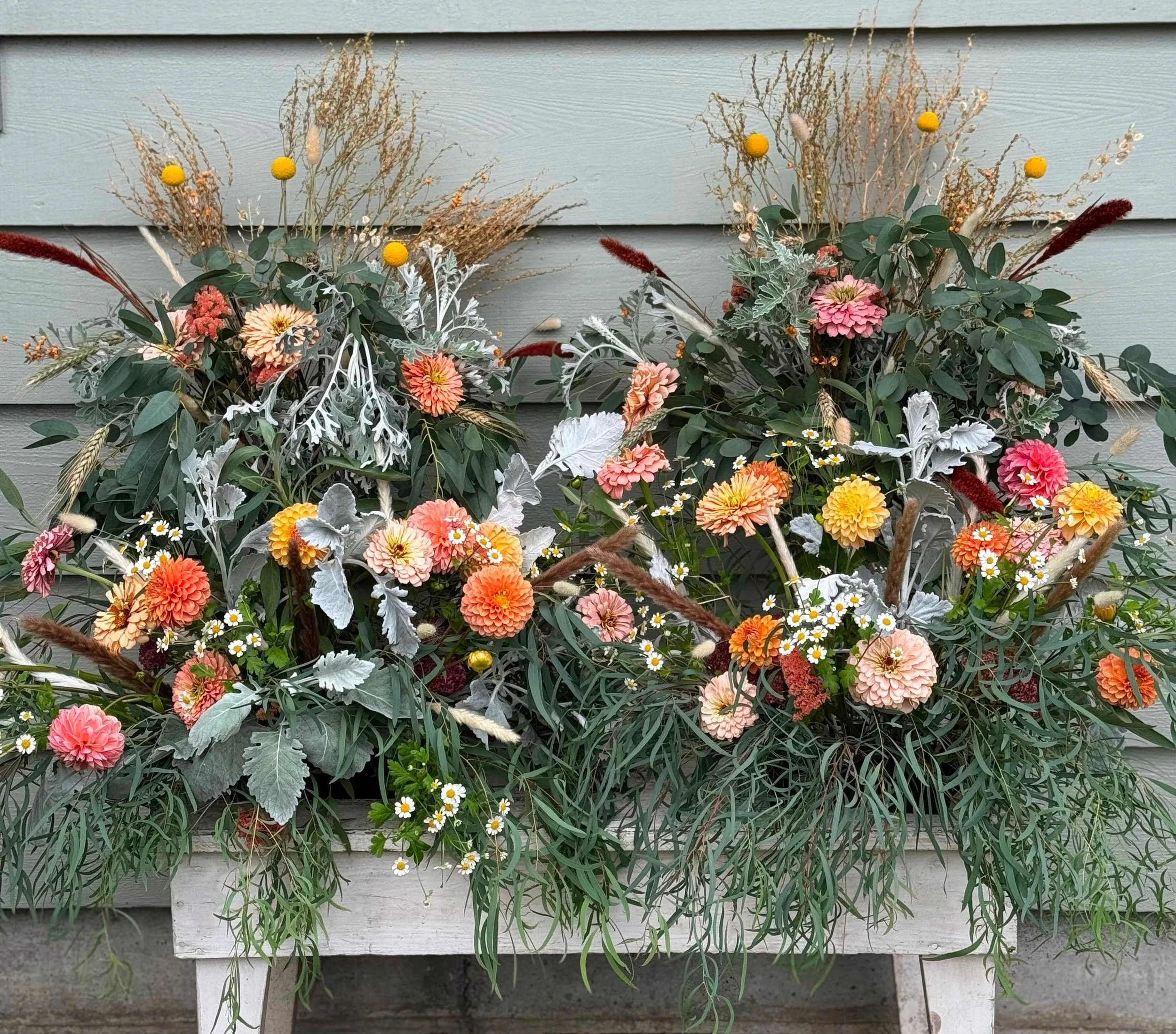 Colorful wedding arrangements of various flowers and greenery for a wedding installation.
