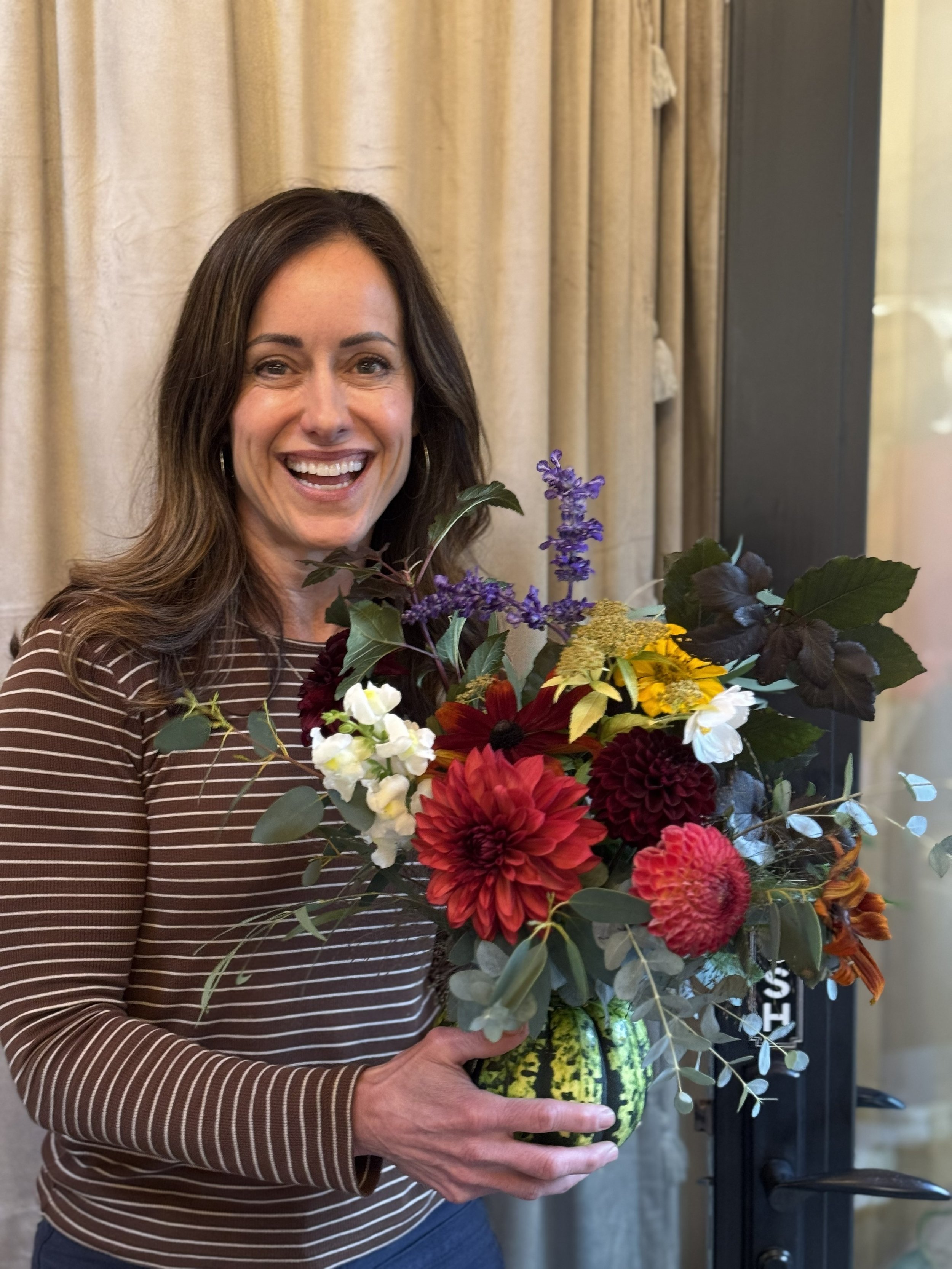 woman with complete pumpkin at KBB pumpkin bouquet bar 2025.jpg