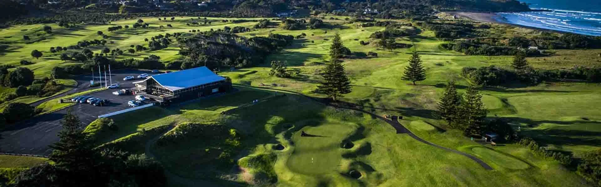 Aerial view of a golf course with clubhouse and ocean view