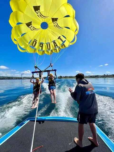Parachute ascensionnel au-dessus de la baie des &Icirc;les ou du lac Taupō. Visites d'aventure panoramiques avec Great North Tours.