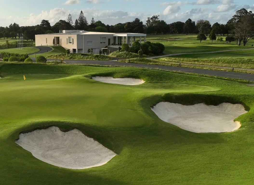 Golf course with sand bunkers and clubhouse in the background