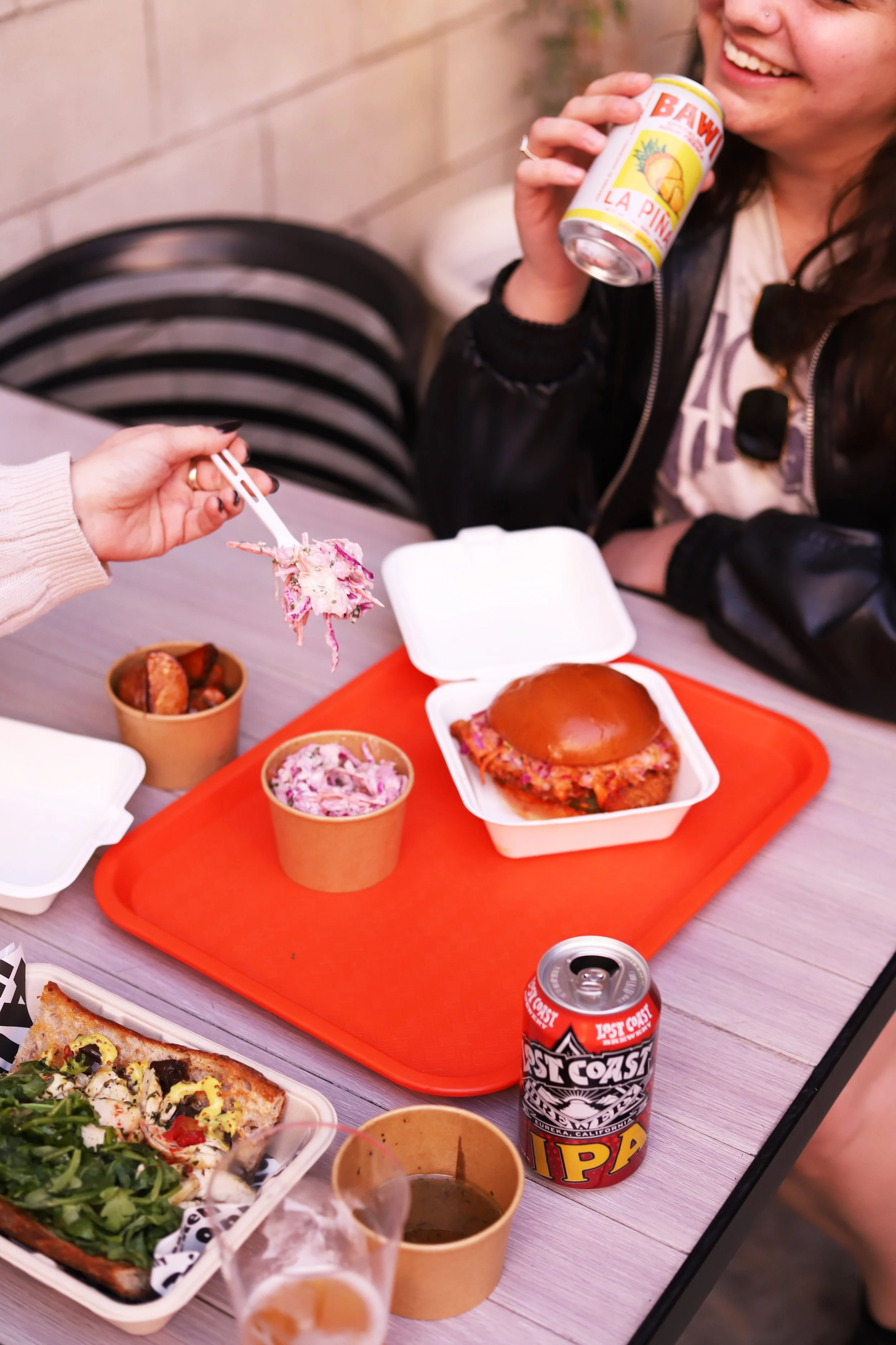 Friends enjoying dinner with fried chicken, Cole slaw, and roasted chicken sandwich at the best casual restaurant in Santa Monica
