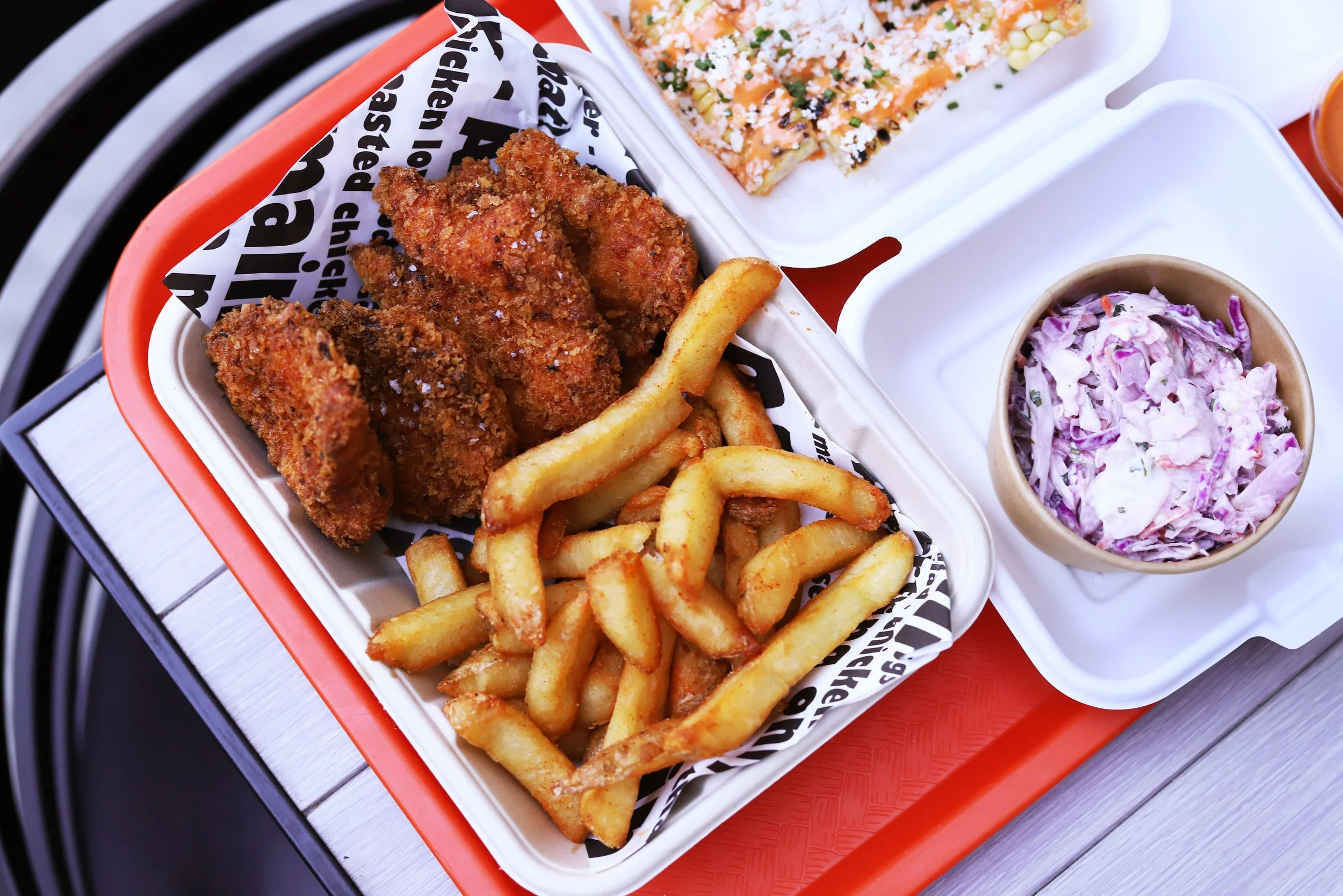 chicken tenders, fries, Cole slaw, and corn on the Cobb elote style at the best chicken restaurant in Santa Monica