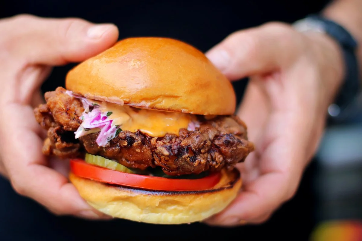 Chef Josiah Citrin holding the Fried Chicken Sandwich