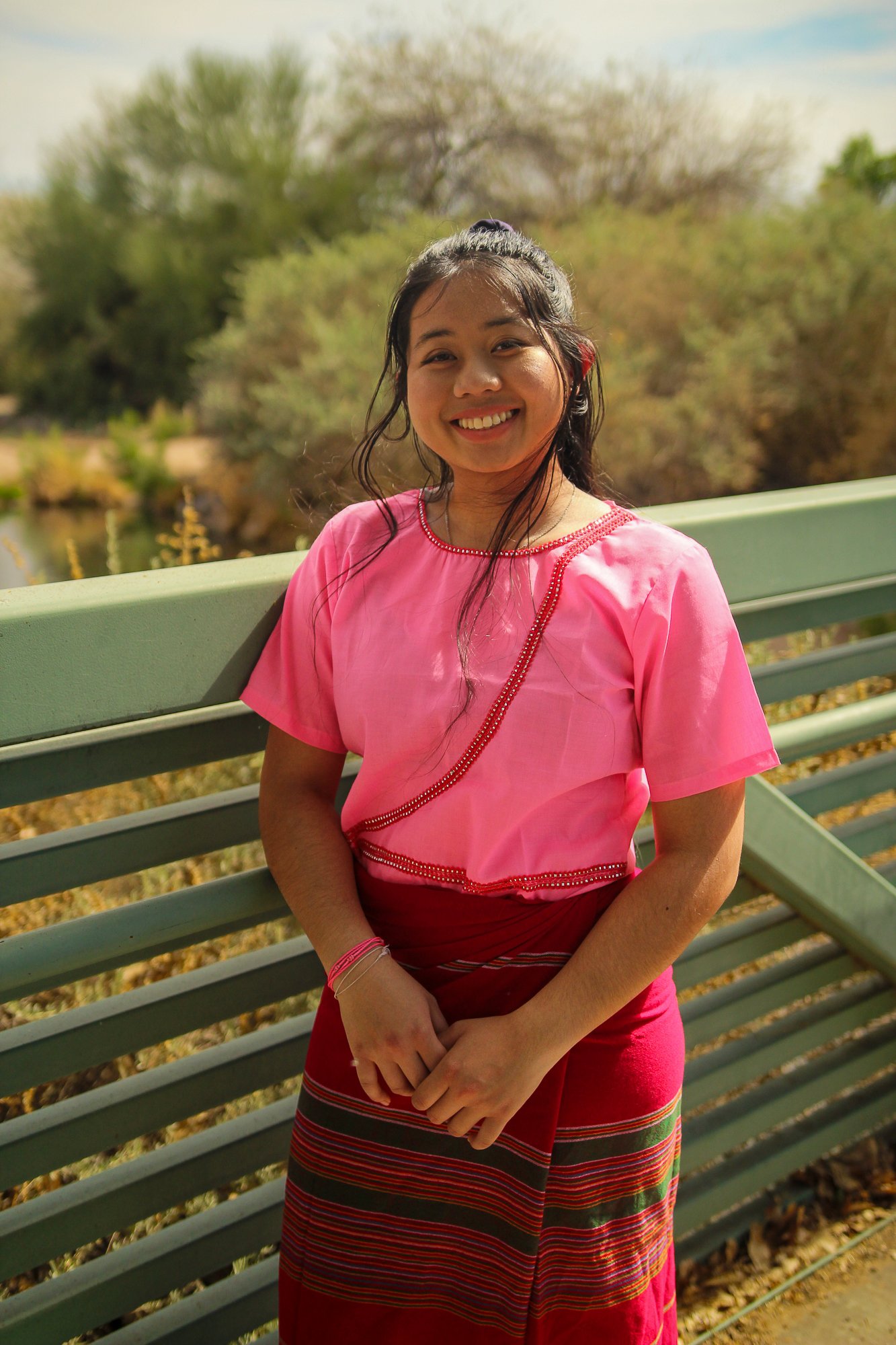 Mi Meh in traditonal Thai clothes on a bridge.