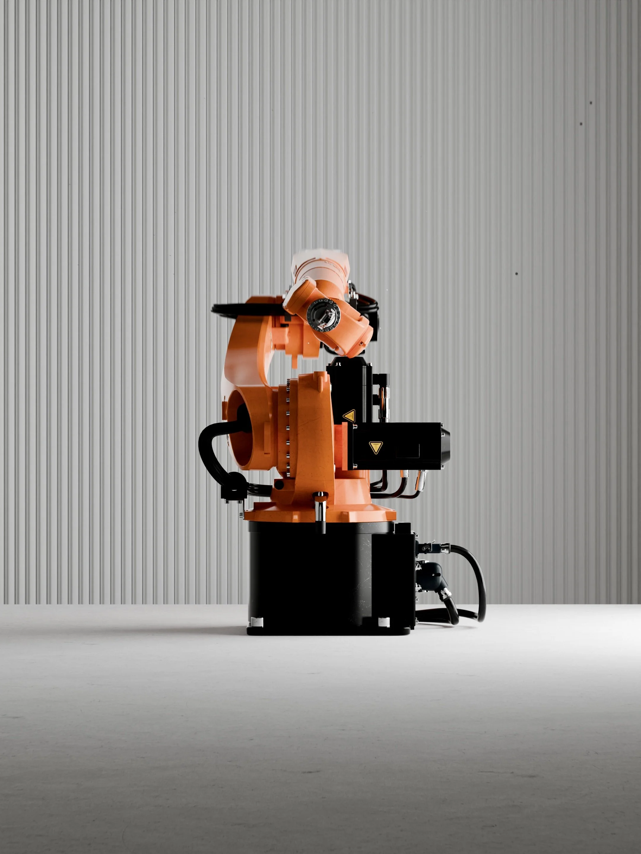 A robotic arm with an orange and black color scheme, positioned in a white industrial space with a corrugated metal wall in the background, connected to a black base.