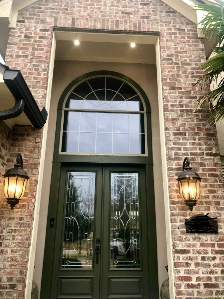 Front entrance with double glass doors and brick exterior