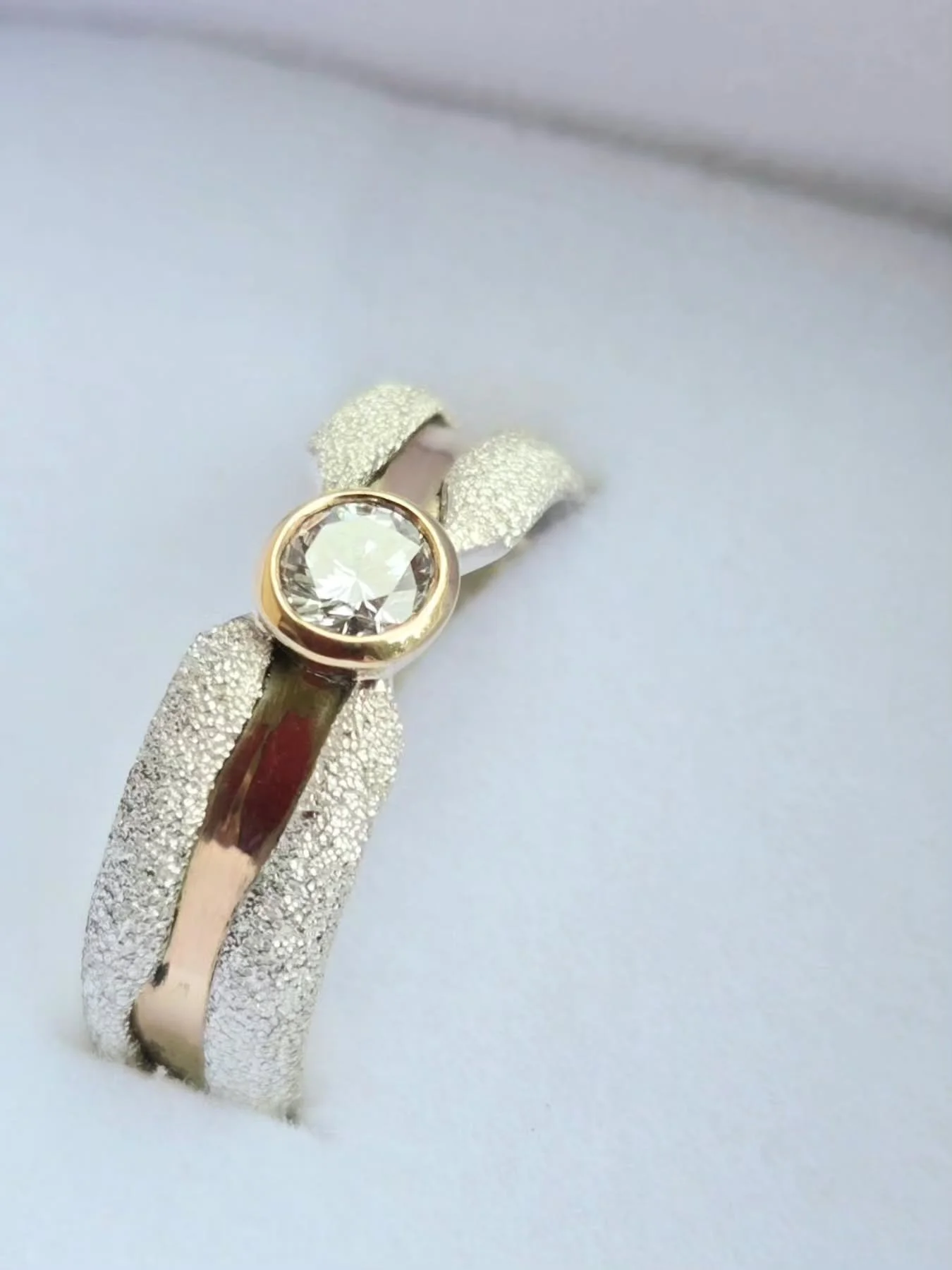 We just love this texture! Contrasted with the smooth polished gold, and beautiful diamond this beauty reflects the clients personality perfectly. 

Specializing in custom engagement and wedding rings is a true honour here in New Brunswick. Thats wha