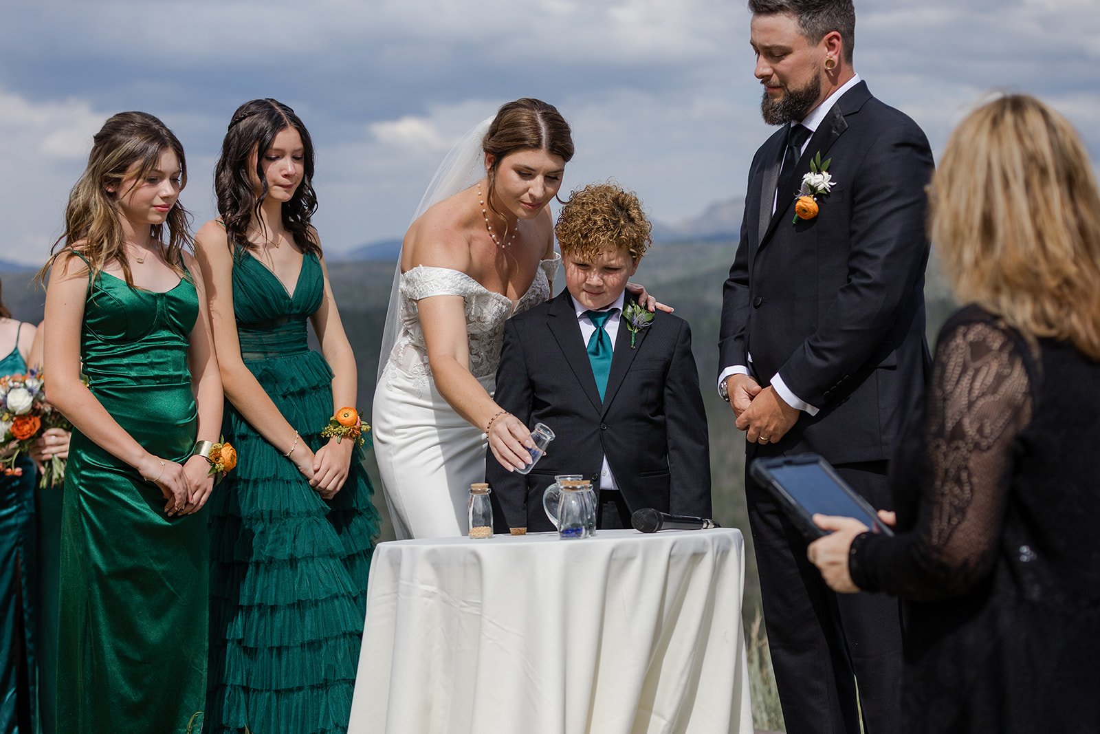 Couple sharing a unity ceremony with their kids during their wedding ceremony at Granby Ranch. Photography by Trail Magic Elopements and Micro Weddings.