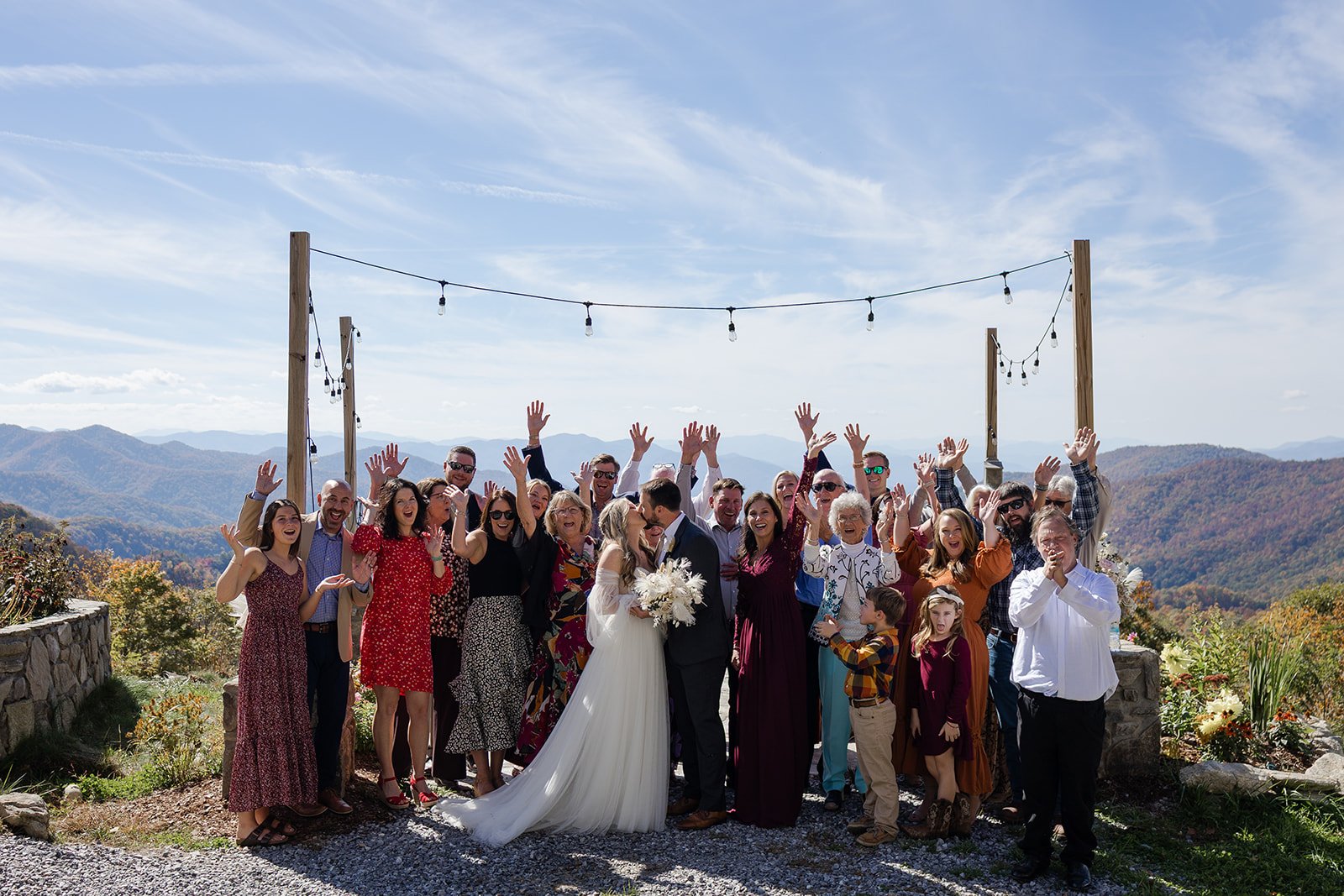 Couple kissing while all of their guests cheer at their micro wedding celebration in Cherokee, North Carolina. Photography by Trail Magic Elopements and Micro Weddings.