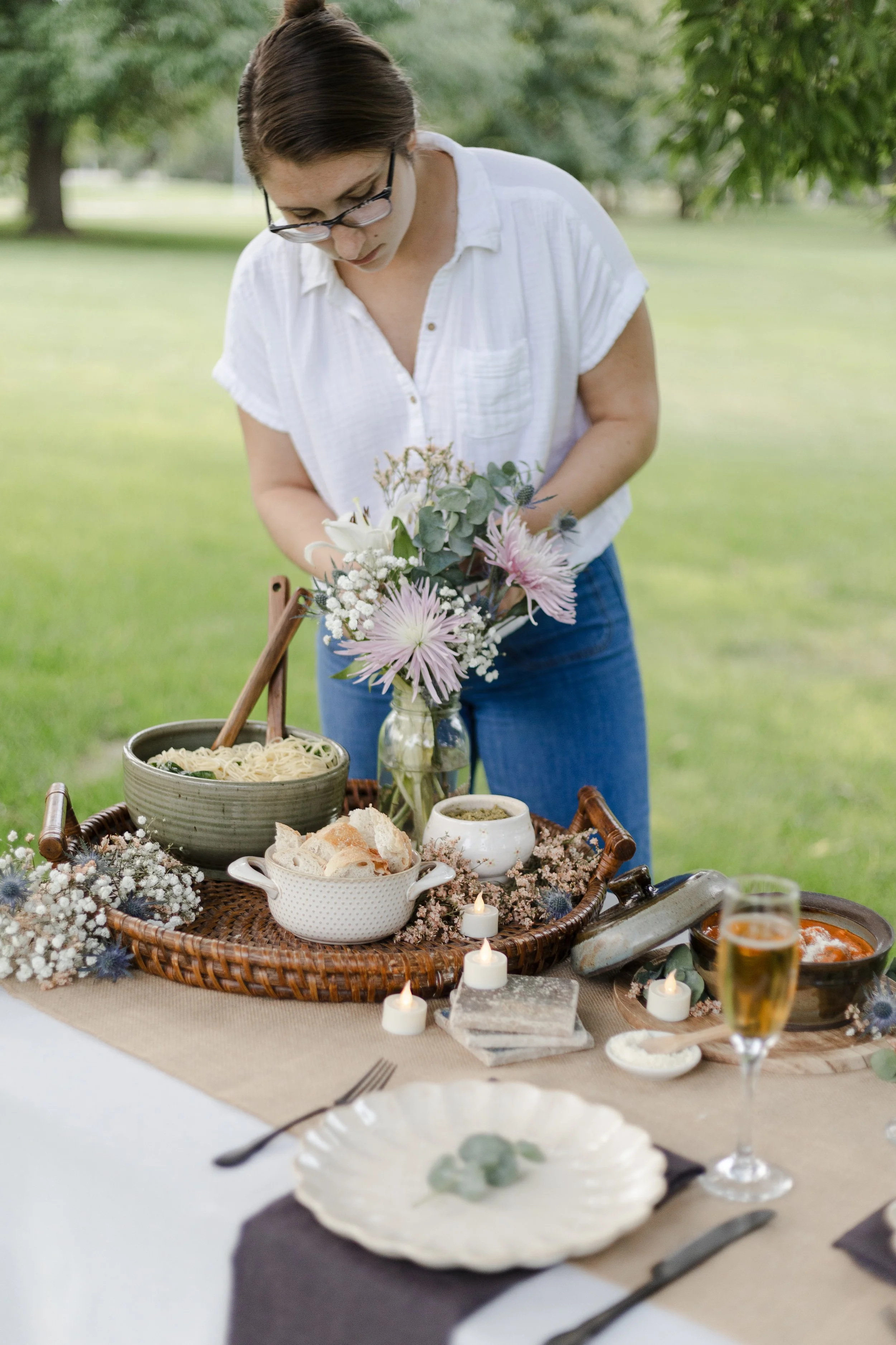Elopement planner setting up a beautiful dinner picnic for her couple. Photography by Trail Magic Elopements and Micro Weddings.