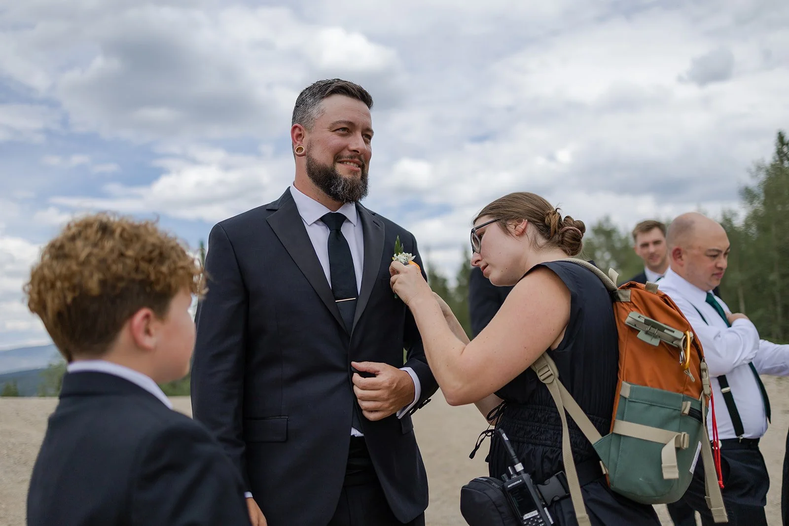 Day-of-Coordinator helping the groom pin his boutonniere before his wedding ceremony at Granby Ranch. Photography and Coordination by Trail Magic Elopements and Micro Weddings.