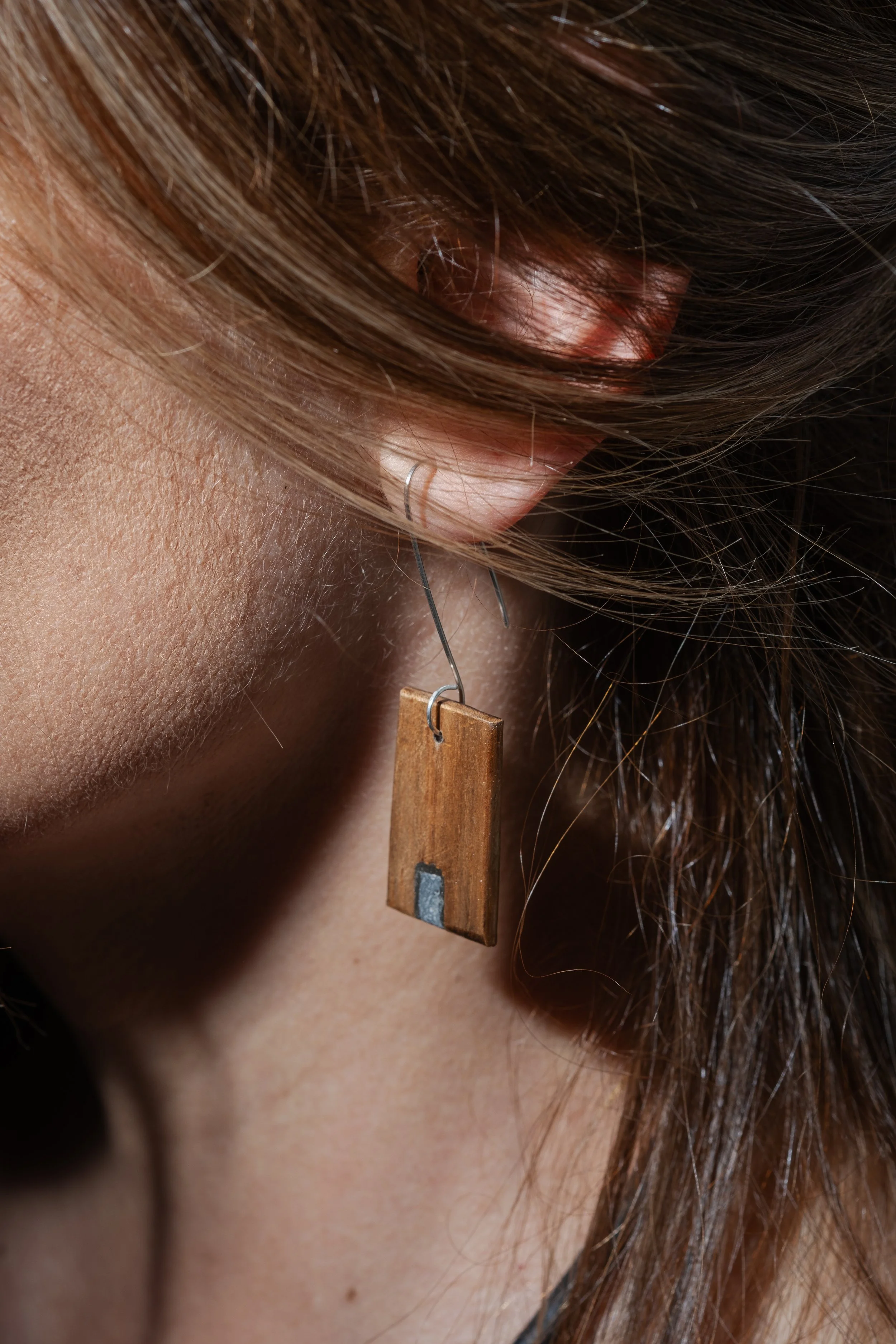 "Repasso vertical"_ Brinco caído, singular ou par assimétrico. Materiais: ignímbrito polido e acácia. Gancho em prata. 