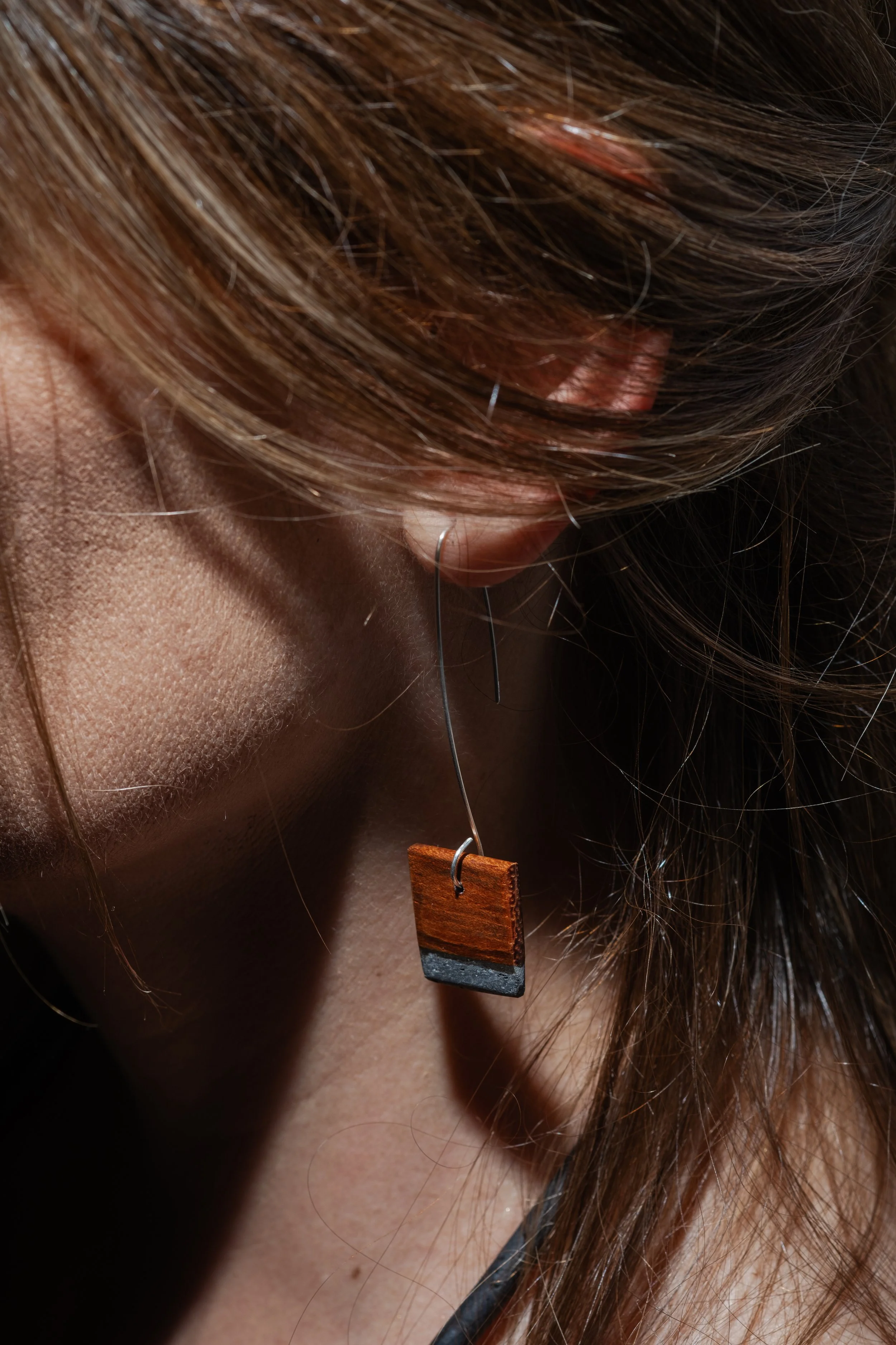 "Repasso horizontal"_ Brinco caído, singular ou par assimétrico. Materiais: ignímbrito polido e acácia. Gancho em prata. 