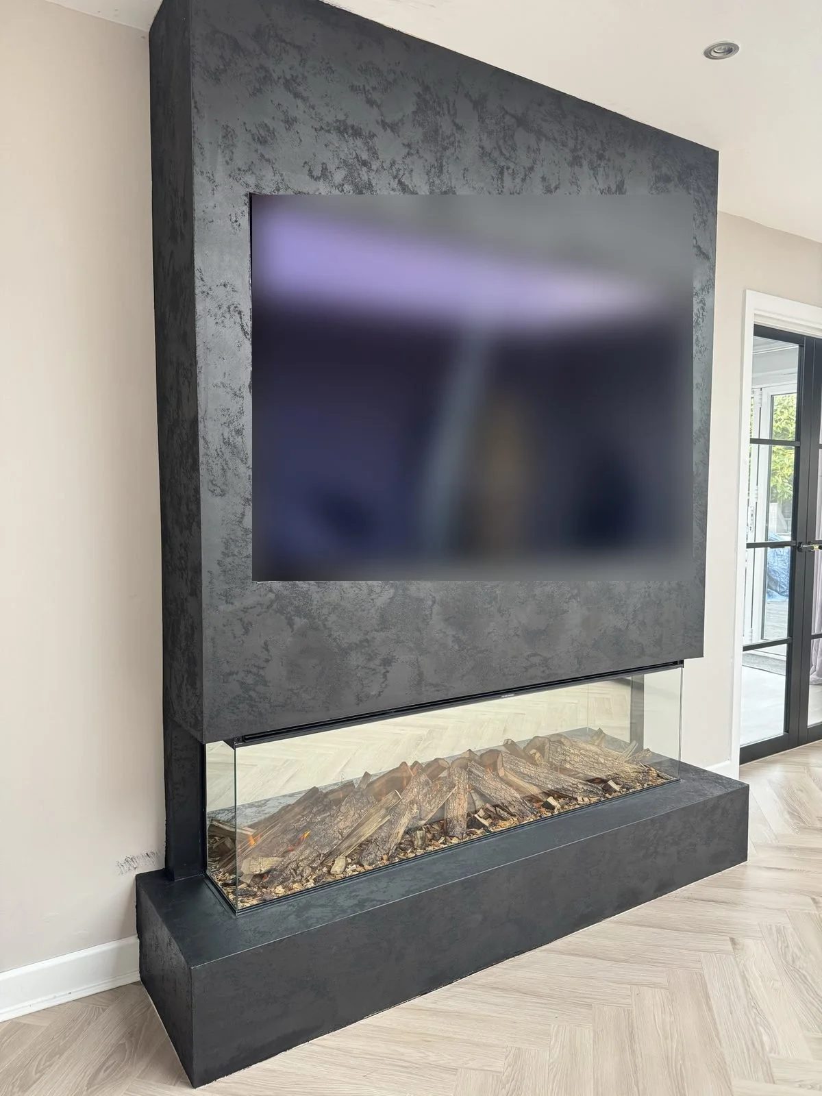 Dark textured fireplace media wall with a three-sided electric fire