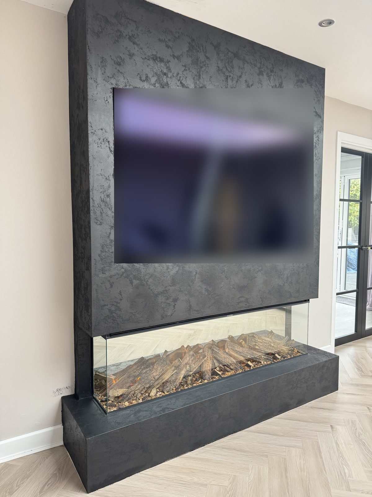 Dark textured fireplace media wall with a three-sided electric fire