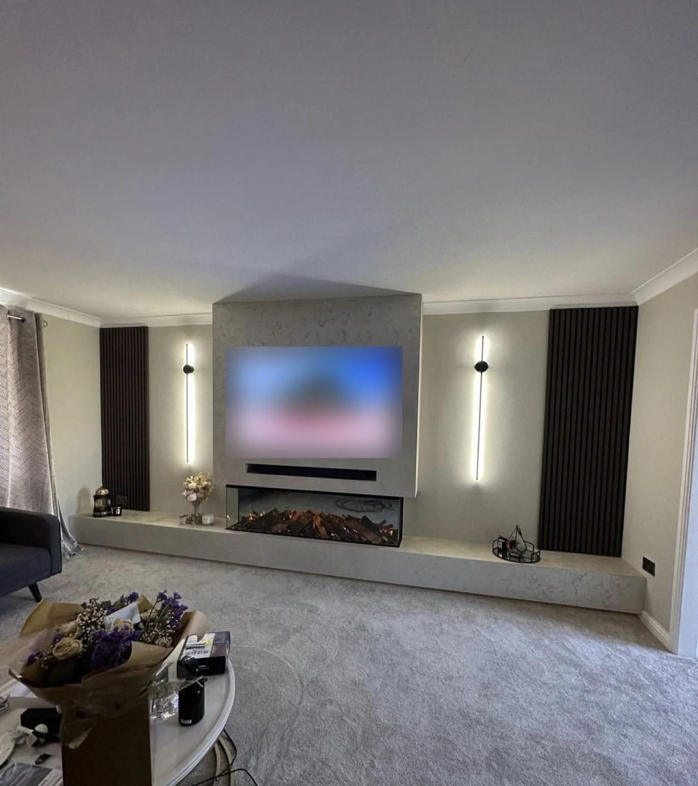 Light stone-effect media wall with slat panels, wall lights and an electric fire