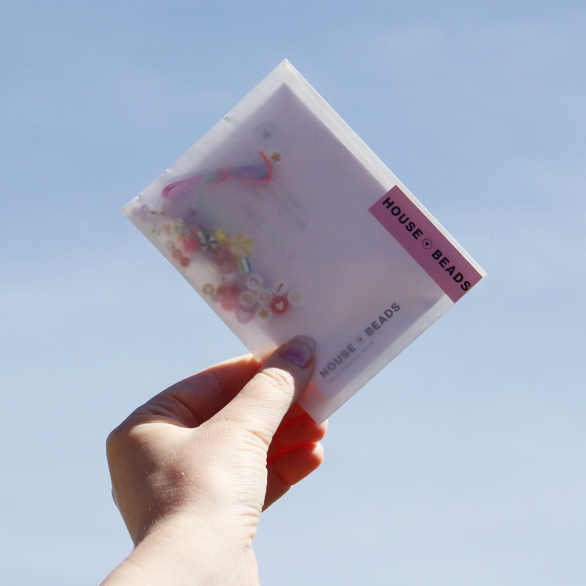 Friendship Bracelet Kit, being held up against a blue sky
