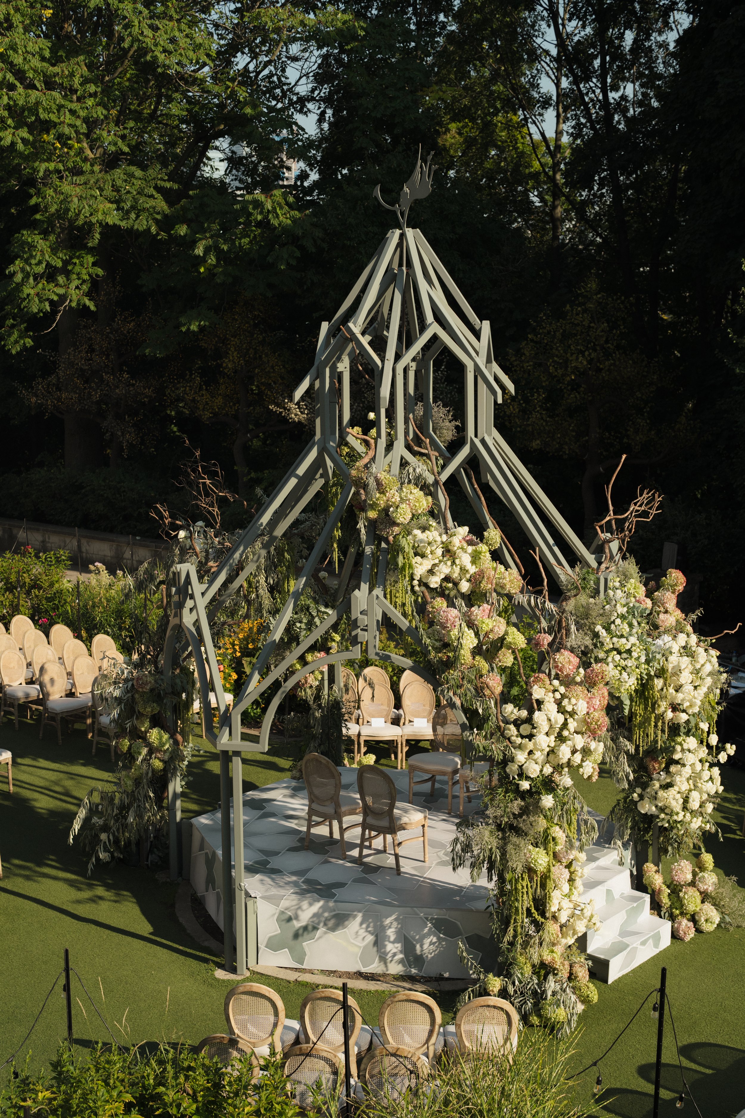 Luxury wedding ceremony decor at the Casa Loma Gazebo in Toronto, featuring a custom floral chuppah with white and blush blooms.