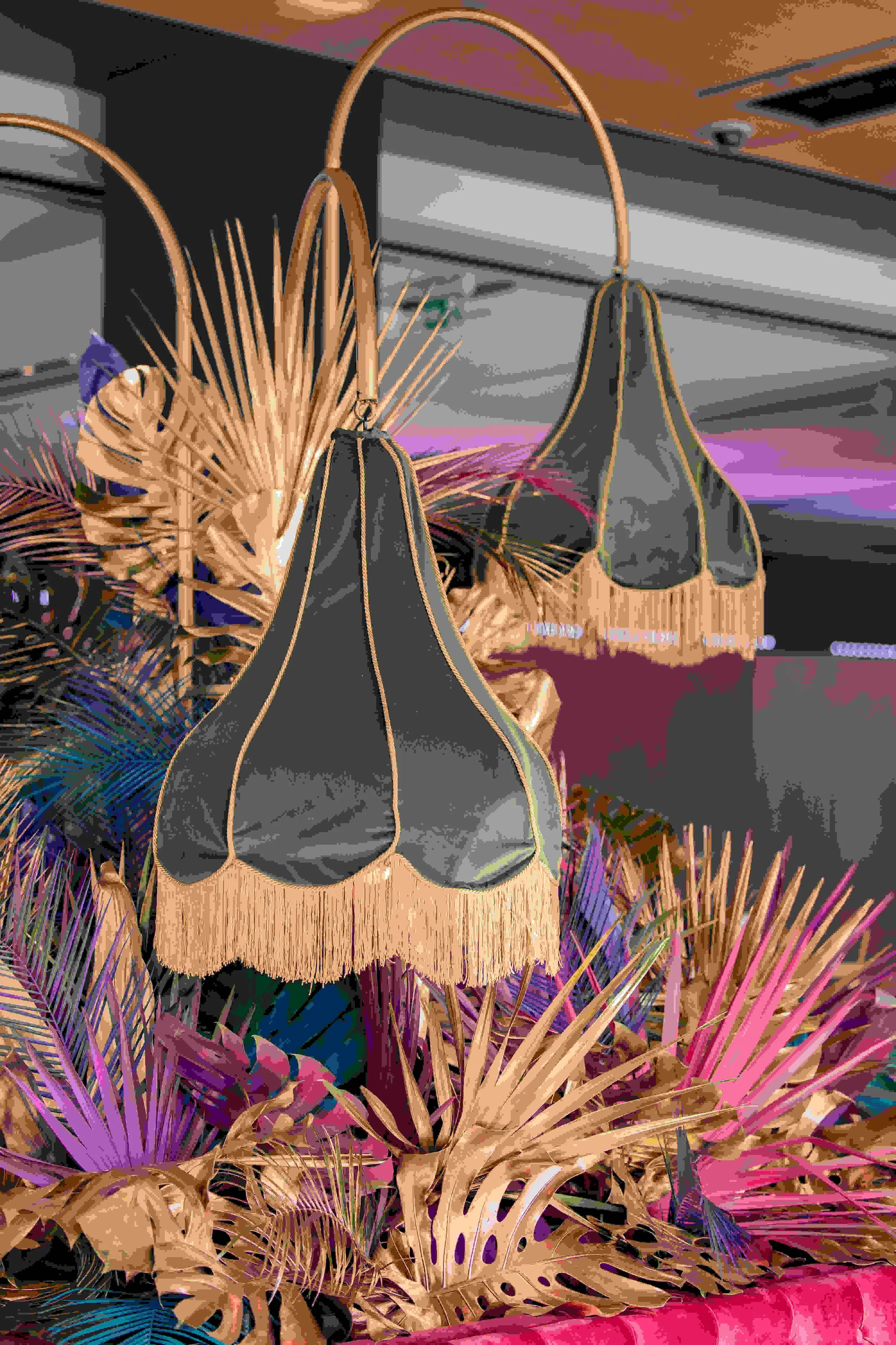 Colorful display of tropical plants and woven bags with a fringe, set in a modern interior.