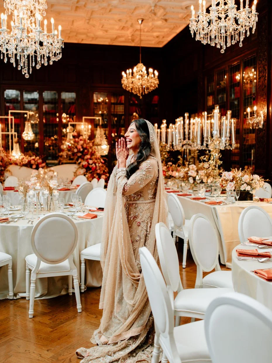 Luxury wedding reception decor in the Casa Loma Library, Toronto, with candlelit tables, crystal chandeliers, and elegant floral styling.