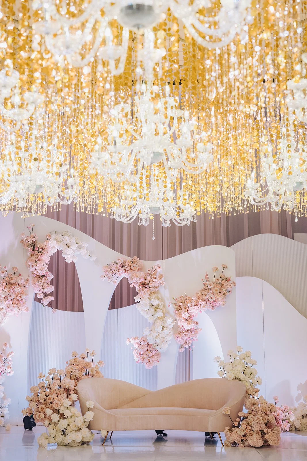 Blush and gold wedding stage with a white wave backdrop and pink cherry blossoms at Château Le Parc, by Ethereal Creators.