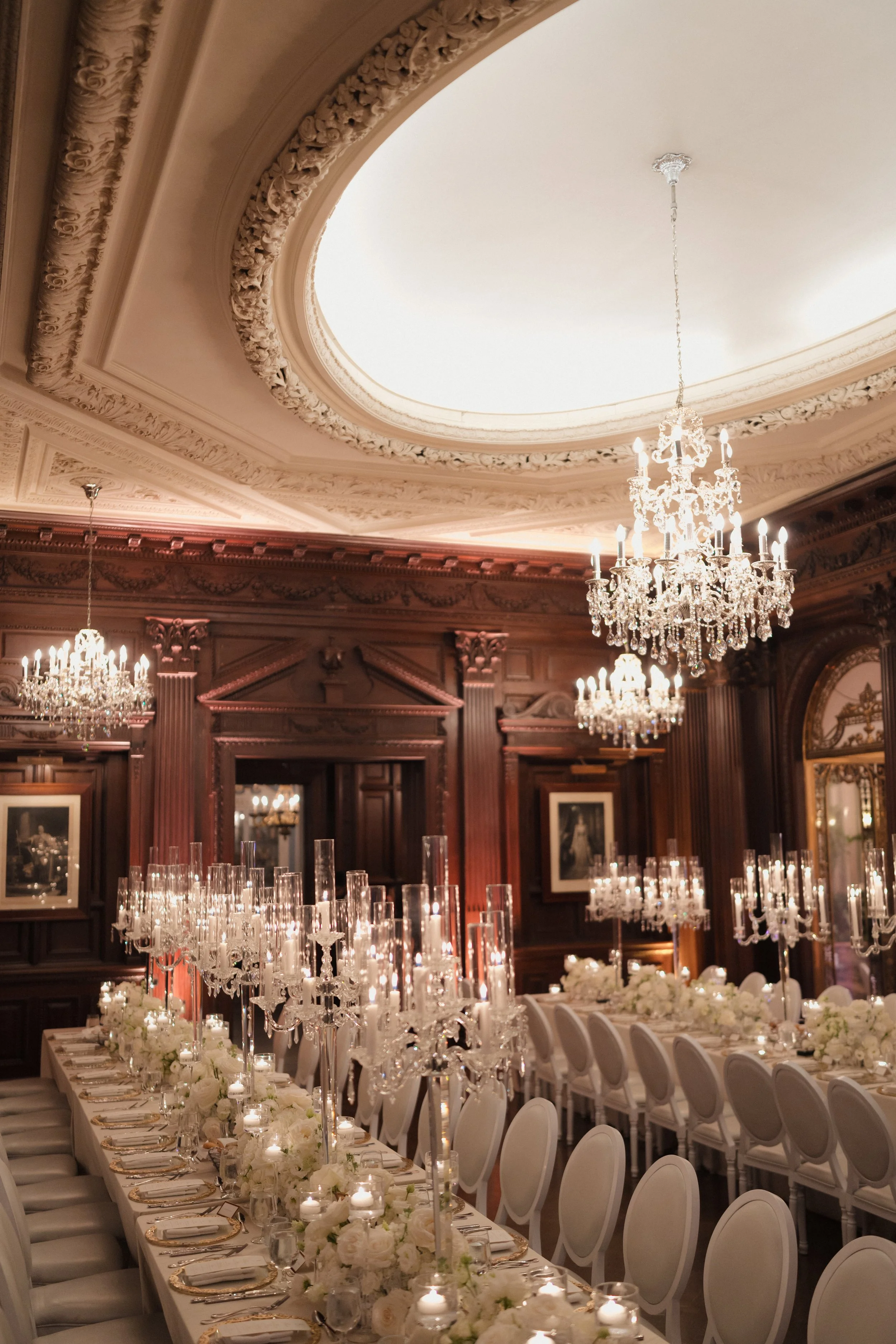A real luxury wedding reception in the Casa Loma Library, Toronto, designed with crystal candelabras, candlelight styling, and bespoke floral decor.