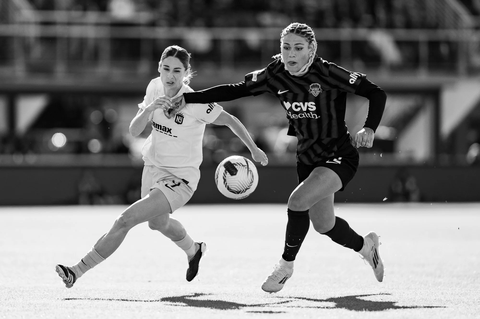 Washington Spirit forward Trinity Rodman and Gotham FC forward Esther González challenge for a 50/50 ball during the NWSL Playoff Semifinal at Audi Field in 2024. The moment is captured in black and white. (Cody Cervenka/Crvnka Photography)