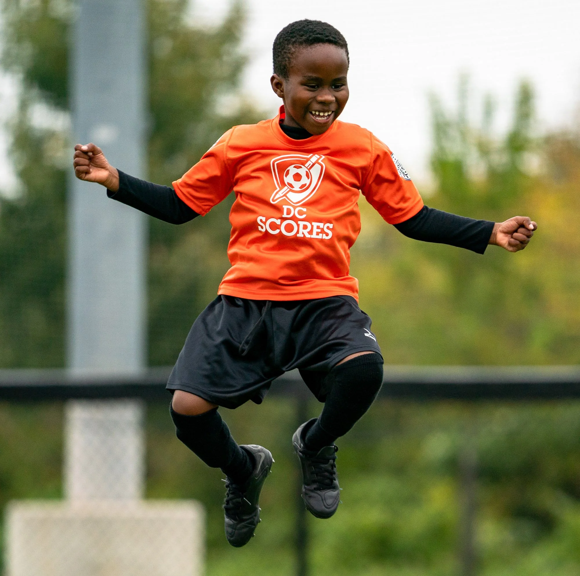 dc-scores-poet-athlete-jumping-smiling-youth-soccer-poetry-program-washington-dc-crvnka-photography.JPG