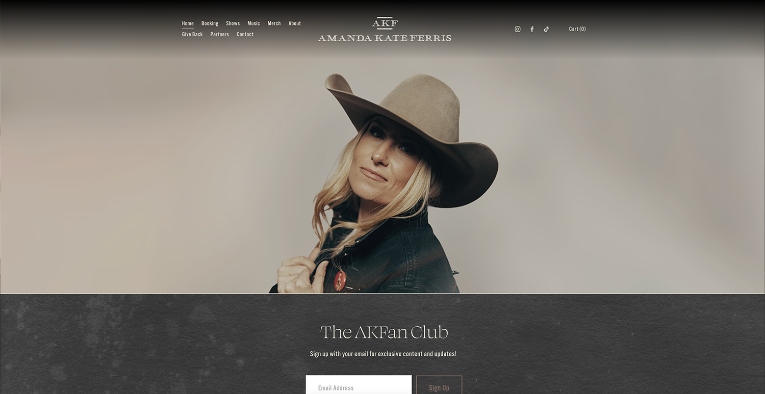 A woman wearing a beige wide-brim hat and a black leather jacket, posing for a photo on a website with a navigation menu at the top.