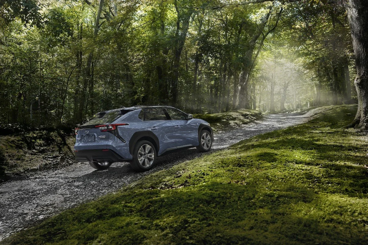 Subaru Solterra electric suv on a trail surrounded by trees