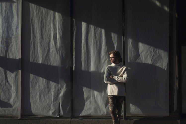From Murray high school graduate senior Dire Dougherty from Murray, senior portrait photograph taken on location in front of Kraft paper background of senior boy with epic shadow coming across the photograph, taken by Brad Rankin Western Kentucky Por