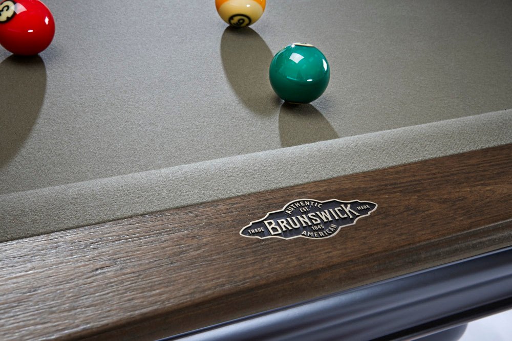 Close-up of a Brunswick pool table with pool balls on the felt surface.